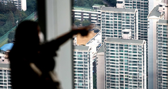 시민이 아파트 밀집 지역을 바라보고 있다. <연합뉴스>